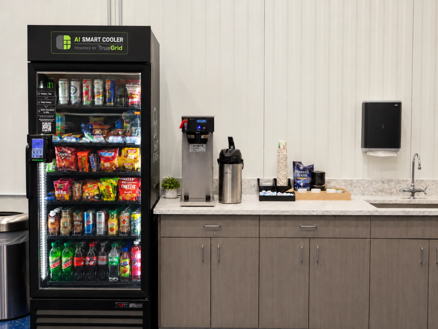 TrueGrid Smart AI Cooler beside an office coffee station with brewer, cups, and supplies