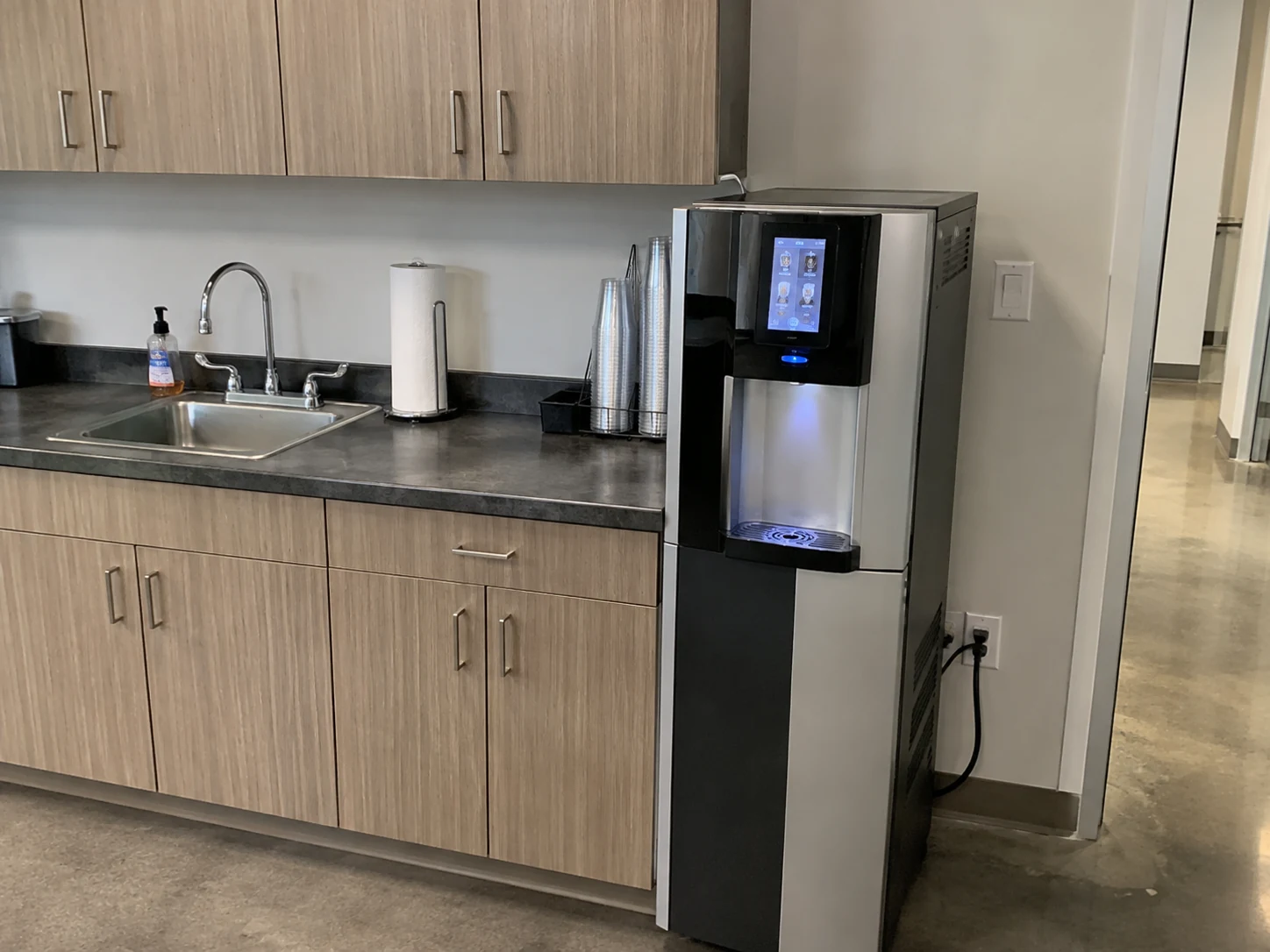 Workplace hydration station with filtered water dispenser, sink, and counter